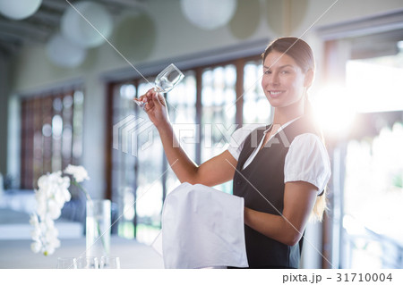 Smiling waitress holding up a empty wine glass Smiling waitress holding up a empty wine glass 31710004