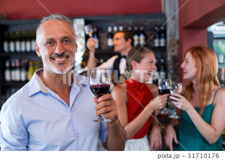 Portrait of smiling man holding glass of red wine Portrait of smiling man holding glass of red wine 31710176