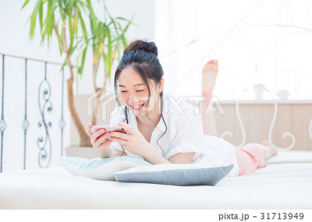 若い女性、スマホ、ベッド、寝転ぶ 若い女性、スマホ、ベッド、寝転ぶ 31713949