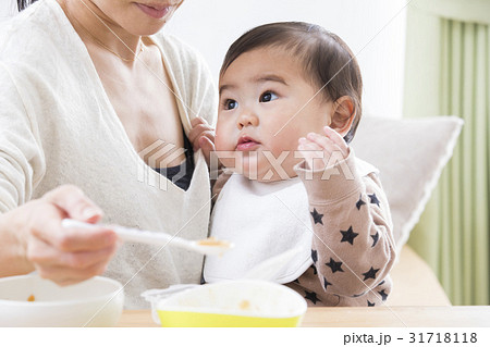 子供に離乳食を食べさせるお母さん 子供に離乳食を食べさせるお母さん 31718118