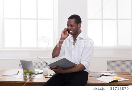 Young black businessman read documents and talk on 31718879