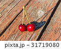 Two cherries are on a wooden table 31719080