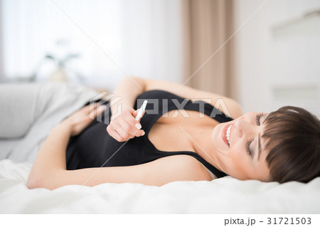 Young beautiful woman holding a pregnancy test. Young beautiful woman holding a pregnancy test. 31721503