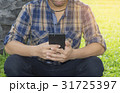 Young man hands typing smartphone in the park. 31725397