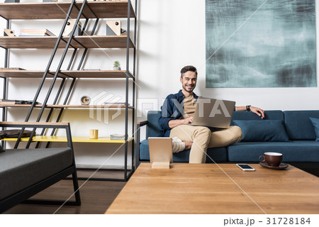 Happy young man working at home via computer 31728184