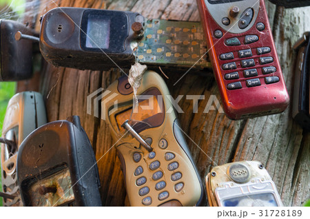 Broken old mobile phones nailed to tree Broken old mobile phones nailed to tree 31728189