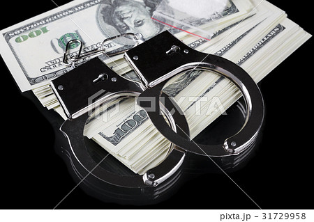 Handcuffs on stack of dollar banknotes and cocaine 31729958