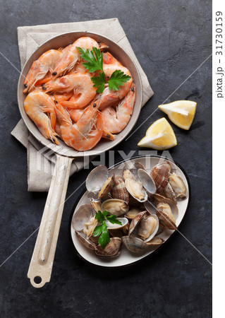 Fresh seafood on stone table. Scallops and shrimps Fresh seafood on stone table. Scallops and shrimps 31730159