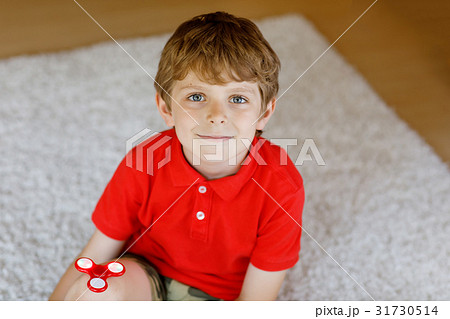 School kid playing with Tri Fidget Hand Spinner 31730514