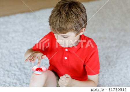 School kid playing with Tri Fidget Hand Spinner School kid playing with Tri Fidget Hand Spinner 31730515