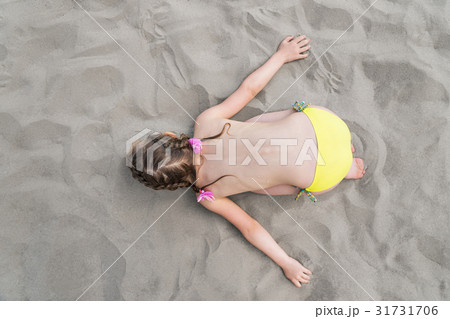 Child represents airplane lying on the sand Child represents airplane lying on the sand 31731706
