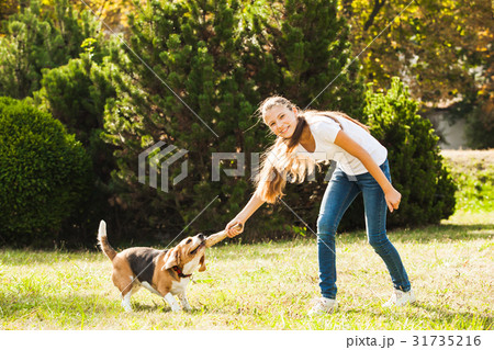 Girl plays with a dog in the yard Girl plays with a dog in the yard 31735216