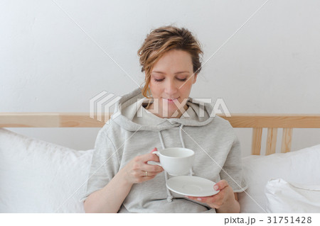 Female having breakfast sitting in bed Female having breakfast sitting in bed 31751428