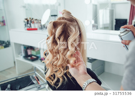 Hair stylist makes a curls for a girl, using hair 31755536