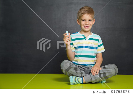 Boy posing with blackboard behind him Boy posing with blackboard behind him 31762878