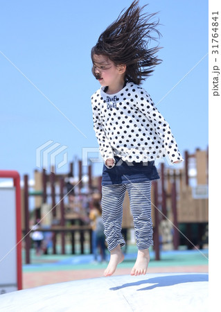 女の子 子供 遊ぶ ジャンプの写真素材