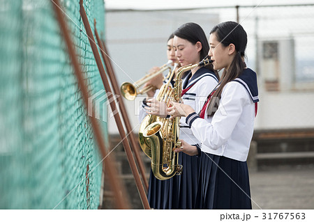 屋上で楽器の練習をする女子高生の写真素材