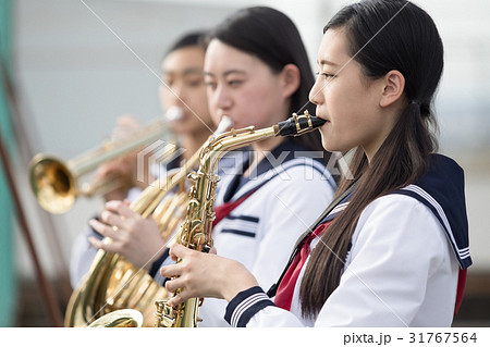 屋上で楽器の練習をする女子高生の写真素材