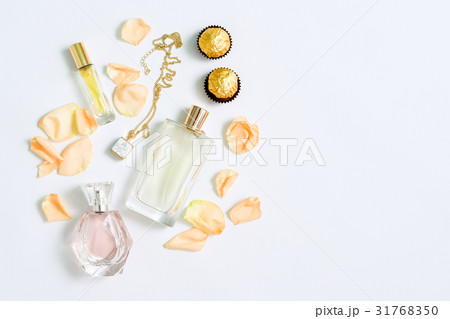 Perfume bottles with flowers petals on white 31768350