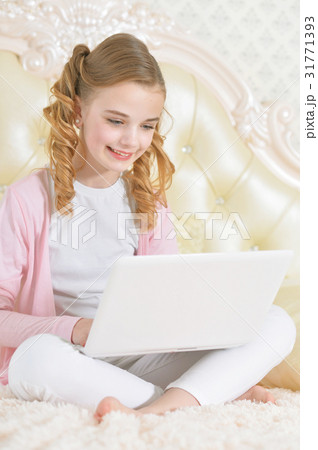 Girl sitting on couch and using modern laptop Girl sitting on couch and using modern laptop 31771393