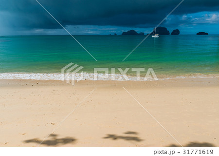 Sandy beach with sun rays before a tropical rain 31771619