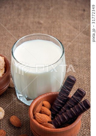 A glass of milk with almond nuts, corn flakes, A glass of milk with almond nuts, corn flakes, 31772349