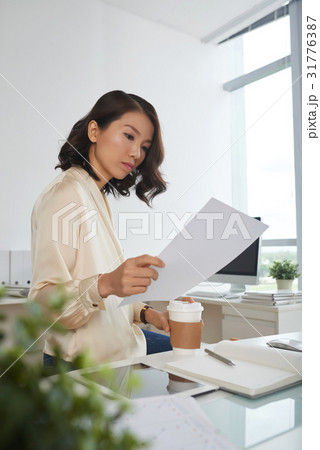 Serious woman reading contract 31776387