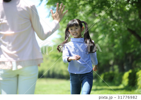 お母さんに駆け寄る娘の写真素材