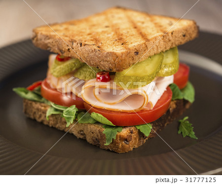 Sandwich with tomatoes, ham salted cucumber on a b Sandwich with tomatoes, ham salted cucumber on a b 31777125