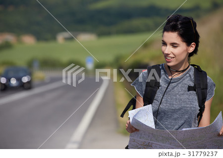 girl holding map with backpack in the road and Tuscany backgroun girl holding map with backpack in the road and Tuscany backgroun 31779237