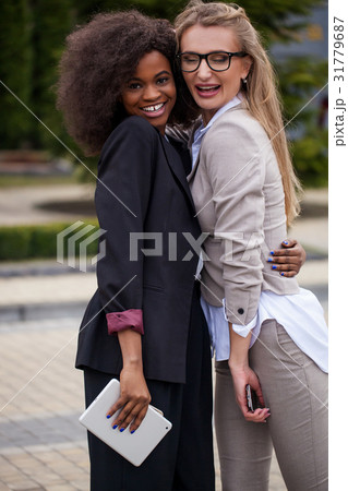 Two happy and successful businesswomen hugging in Two happy and successful businesswomen hugging in 31779687