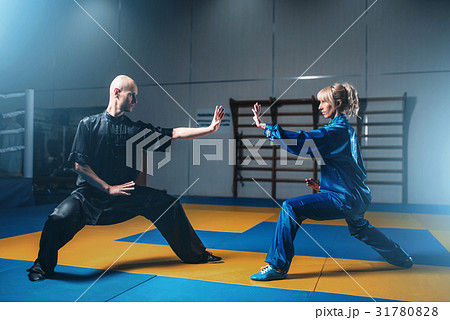 Male and female wushu fighters exercises indoor 31780828