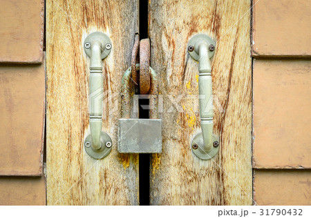 Old rusted lock on a wooden door Old rusted lock on a wooden door 31790432