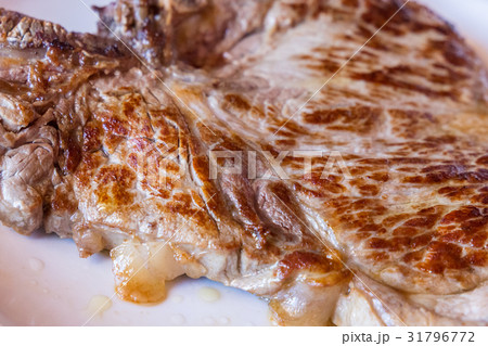 Closeup of a grilled steak on white plate 31796772