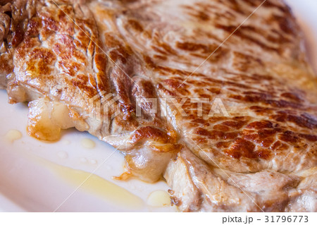 Closeup of a grilled steak on white plate 31796773