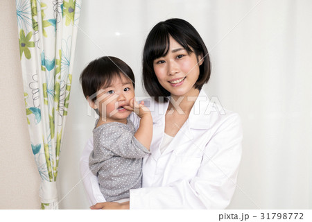 子どもを抱きかかえる白衣の女性 子どもを抱きかかえる白衣の女性 31798772