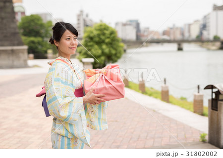 お中元の品物を持つ女性 31802002