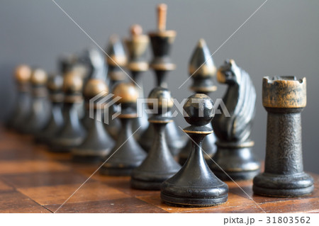 Vintage wooden chess pieces on an old chessboard. Vintage wooden chess pieces on an old chessboard. 31803562