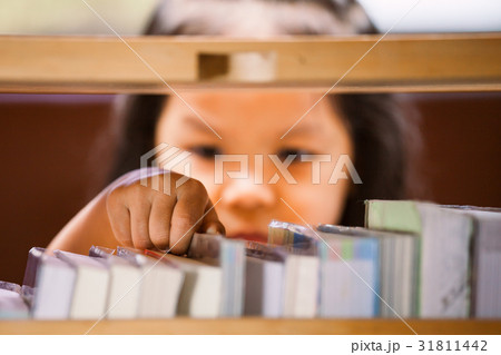 asian little girl is finding a book on bookshelf asian little girl is finding a book on bookshelf 31811442
