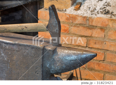 An anvil and a hammer in the old smithy 31823421