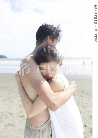 抱き合うカップル 海 海風 湘南の写真素材