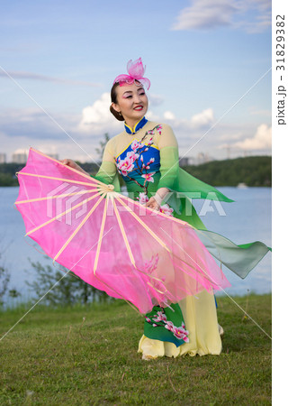 beautiful chinese girl with fan on the riverbank 31829382