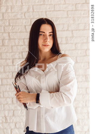 Happy woman holding a makeup brush. Happy woman holding a makeup brush. 31832698