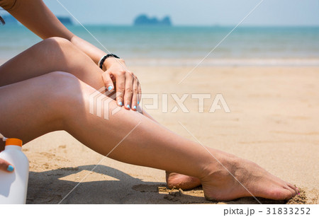 Girl using sun lotion on the beach 31833252