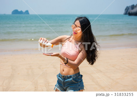Girl using sun lotion on the beach Girl using sun lotion on the beach 31833255