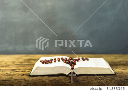 Bible and a crucifix on an old oak table Bible and a crucifix on an old oak table 31833346