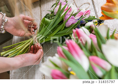 Woman packing tulip bouquet top view 31835797