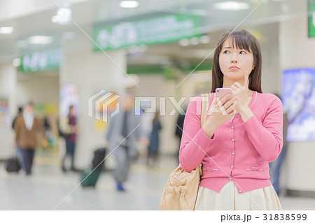 駅で迷う女性 31838599