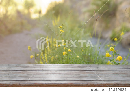 Wooden table with flower field background 31839821