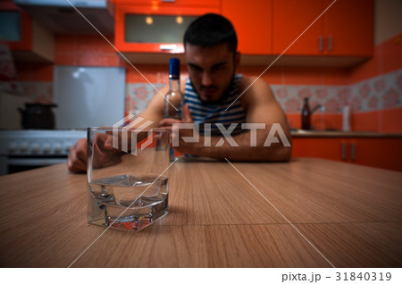 Young drunken man sitting in the kitchen at home 31840319